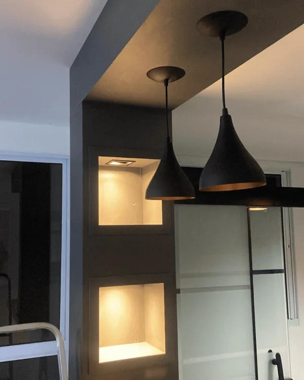 Pendentes pretos e luz indireta em um ambiente interno